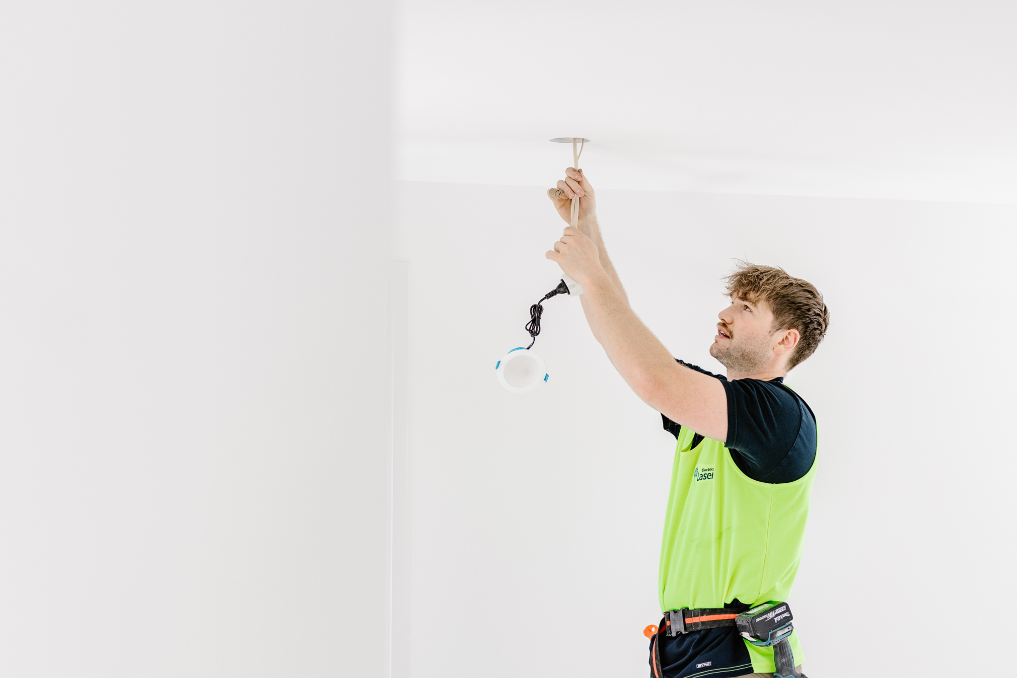 laser electrical staff installing LED downlights in a new home